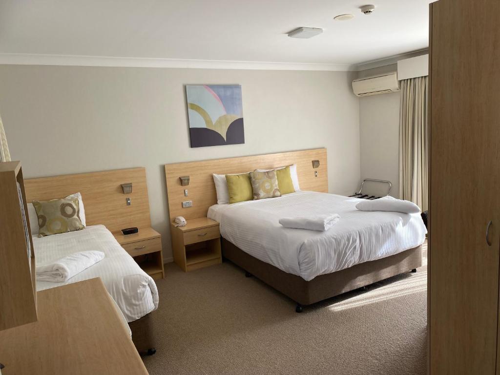 a hotel room with two beds and a window at Maitland City Motel in Maitland
