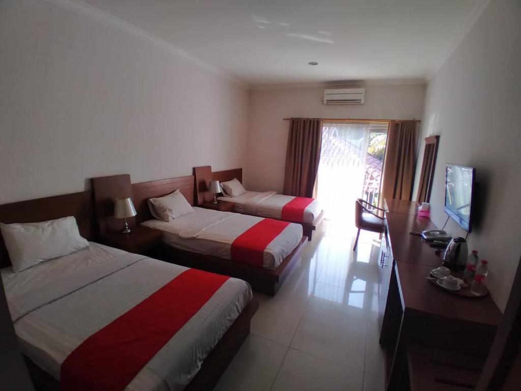 Postel nebo postele na pokoji v ubytování HOTEL & WISMA BINTANG JADAYAT
