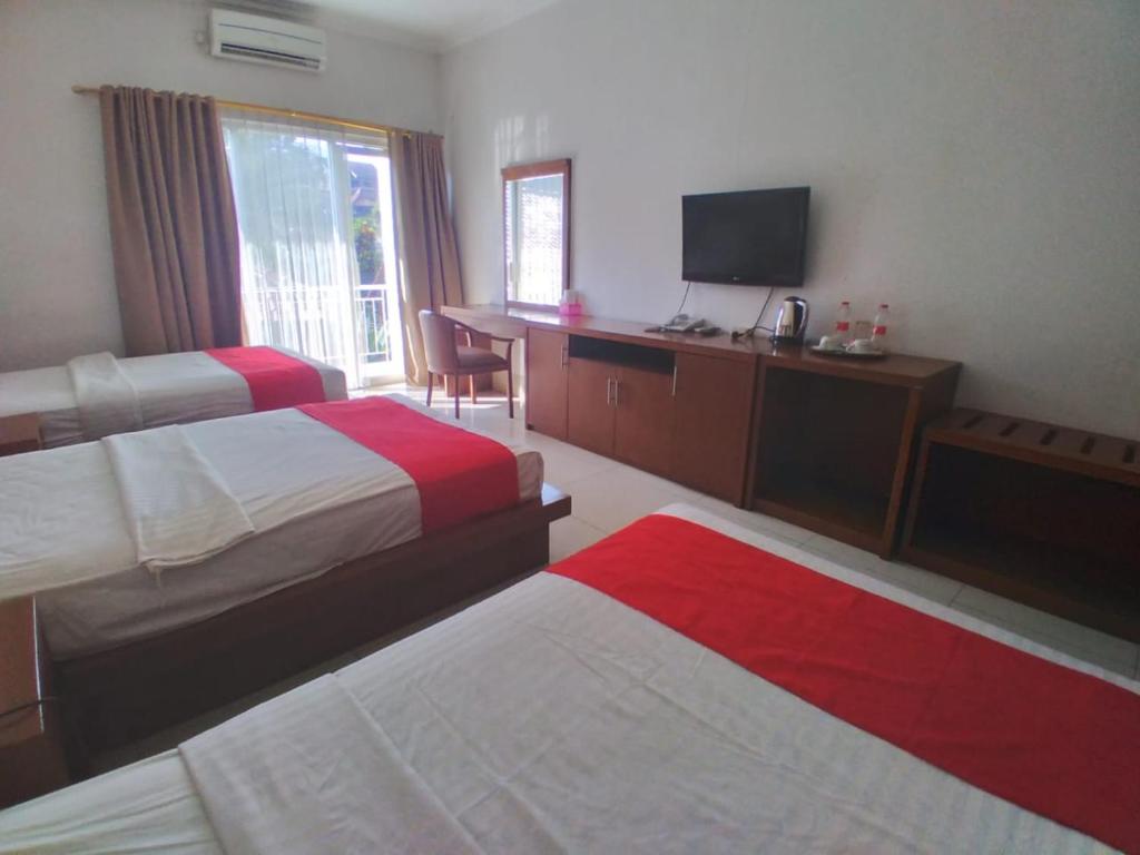 Postel nebo postele na pokoji v ubytování HOTEL & WISMA BINTANG JADAYAT