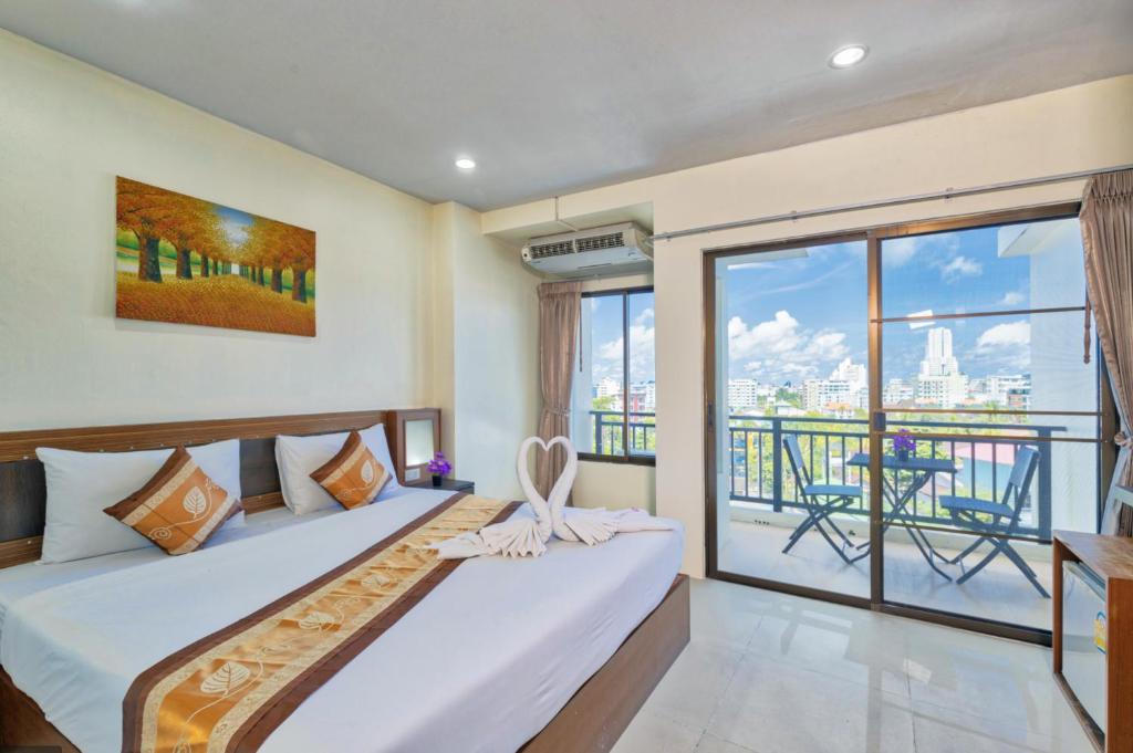 a bedroom with a bed and a balcony at Lucky Buako Hotel Patong in Patong Beach