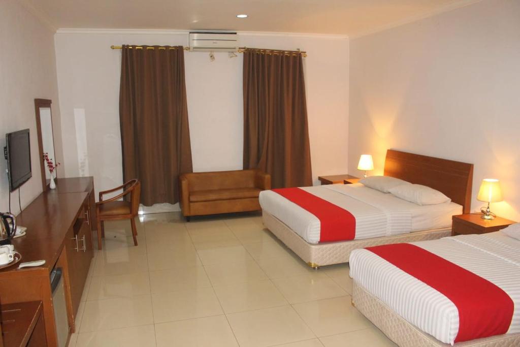 Postel nebo postele na pokoji v ubytování HOTEL & WISMA BINTANG JADAYAT