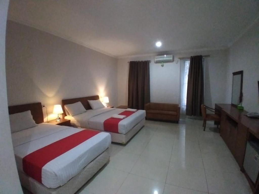 Postel nebo postele na pokoji v ubytování HOTEL & WISMA BINTANG JADAYAT