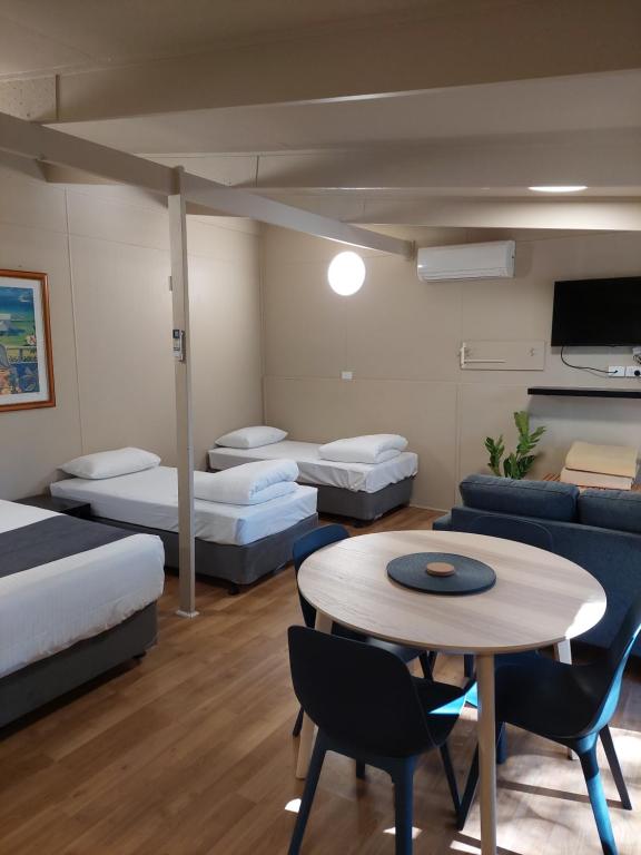 a room with beds and a table and a couch at Robe Holiday Park in Robe