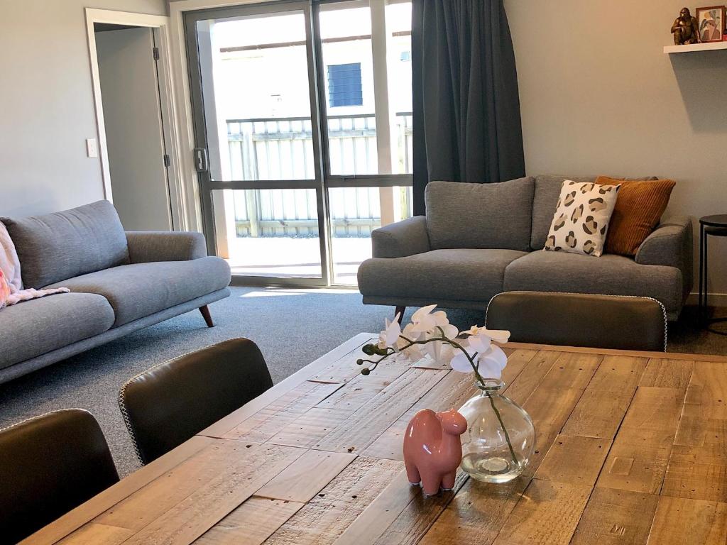 a living room with a table with a vase of flowers on it at Central, Cosy, Convenient in Twizel