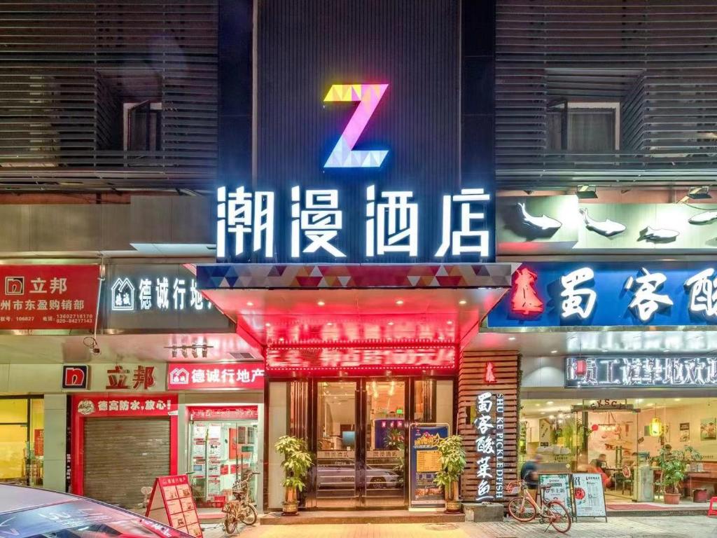 a store with neon signs on the side of a building at Chao Man Hotel(Guangzhou Pazhou Exhibition Center Chigang Subway Station) in Guangzhou