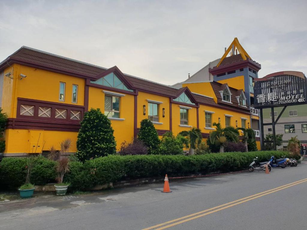 大寮區的住宿－香堤精品旅館，街道边的黄色建筑