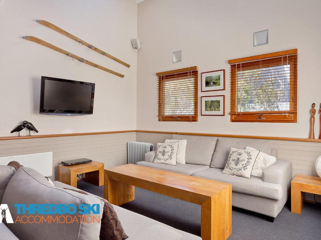 a living room with a couch and a tv at Ramshead Creek 2 in Thredbo