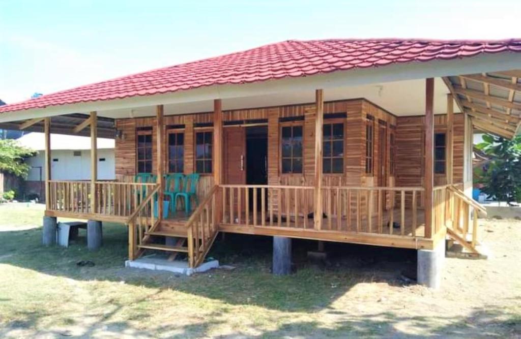 ein großes Holzhaus mit rotem Dach in der Unterkunft Penginapan Erbysa in Mancagahar
