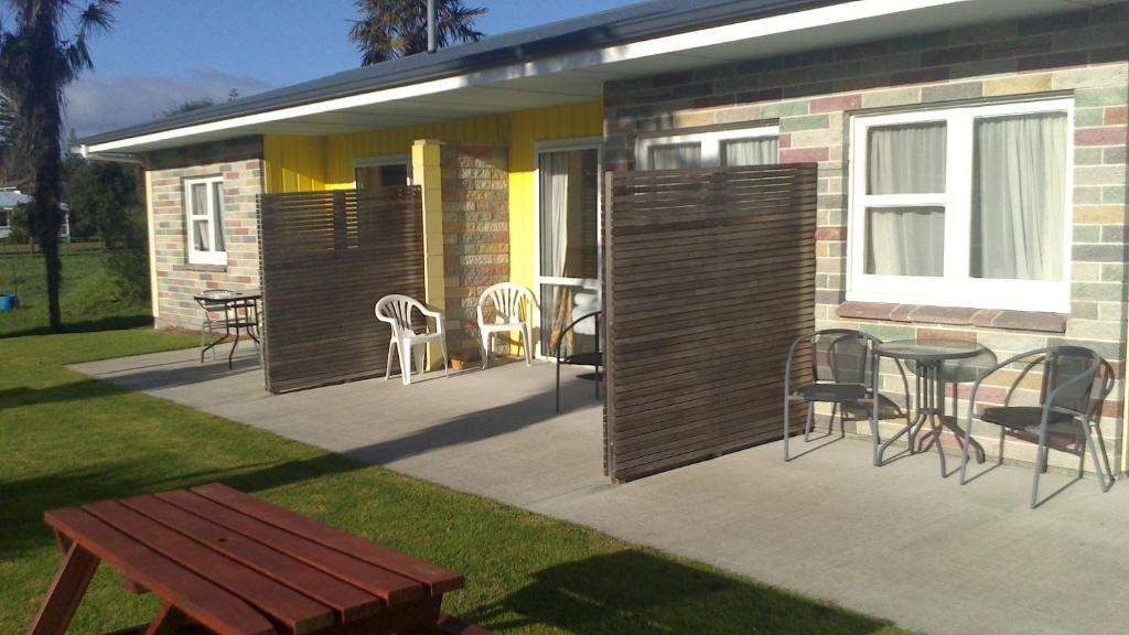 a patio with chairs and a table and a building at Otaki Motel in Otaki