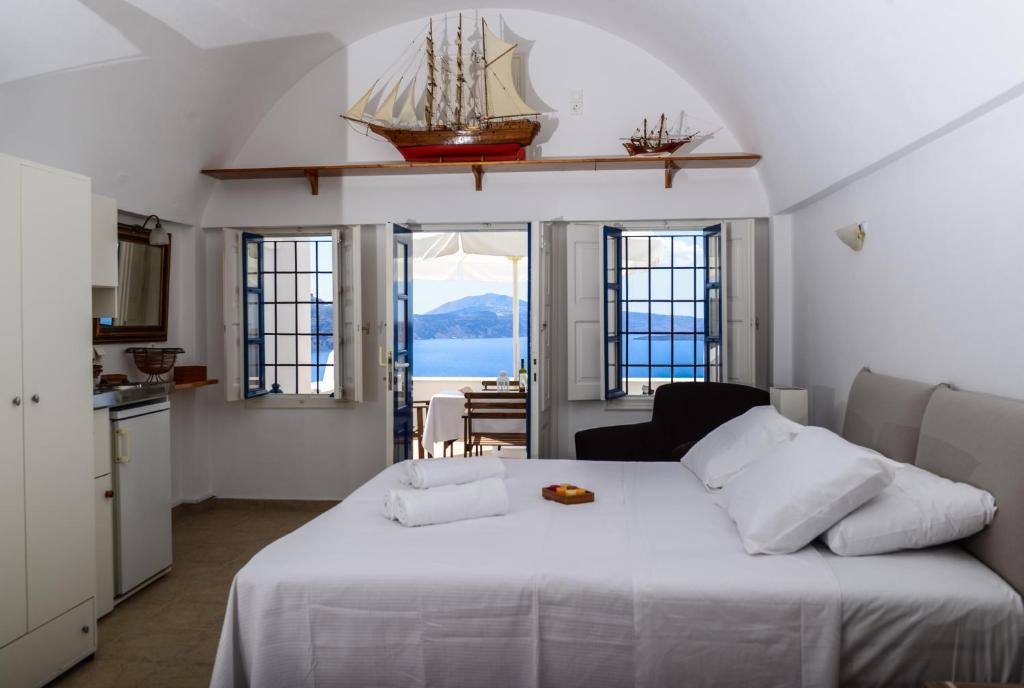 a bedroom with a white bed with a ship on it at Top Oia in Oia
