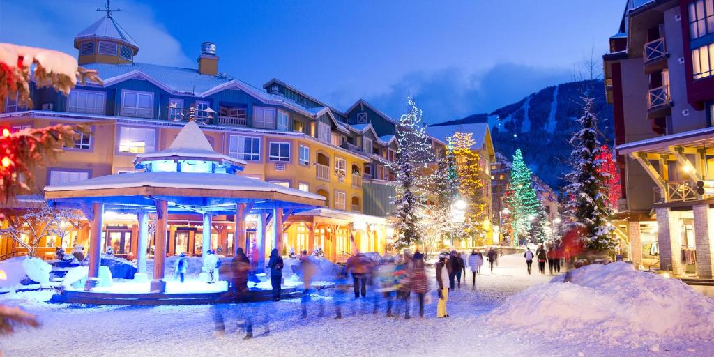 a group of people walking around a town with christmas lights at Whistler Blackcomb Vacation Rentals - Village North in Whistler