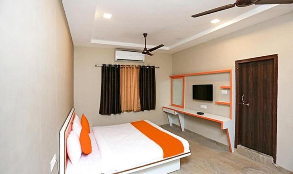 a bedroom with a bed and a desk and a tv at Hotel Edge,Raipur in Raipur