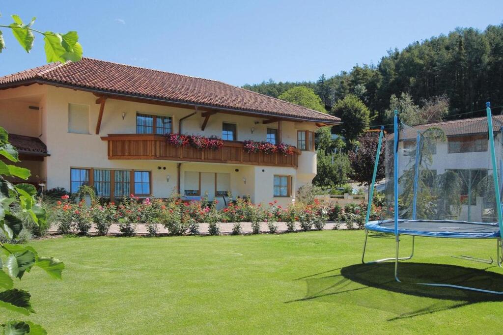 a large house with a yard with a swing at Apartment in Dolomites with Pool Access in Naz-Sciaves