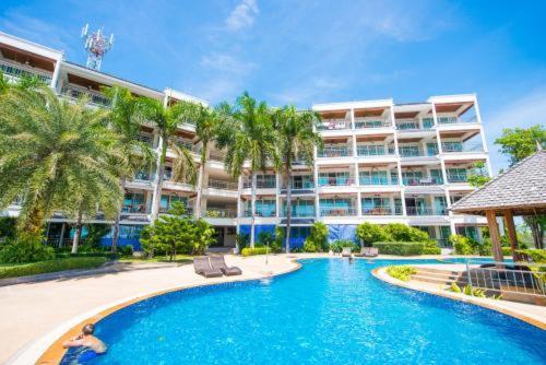 a swimming pool in front of a large building at Spacious apartment with Ocean view in Panwa in Phuket Town