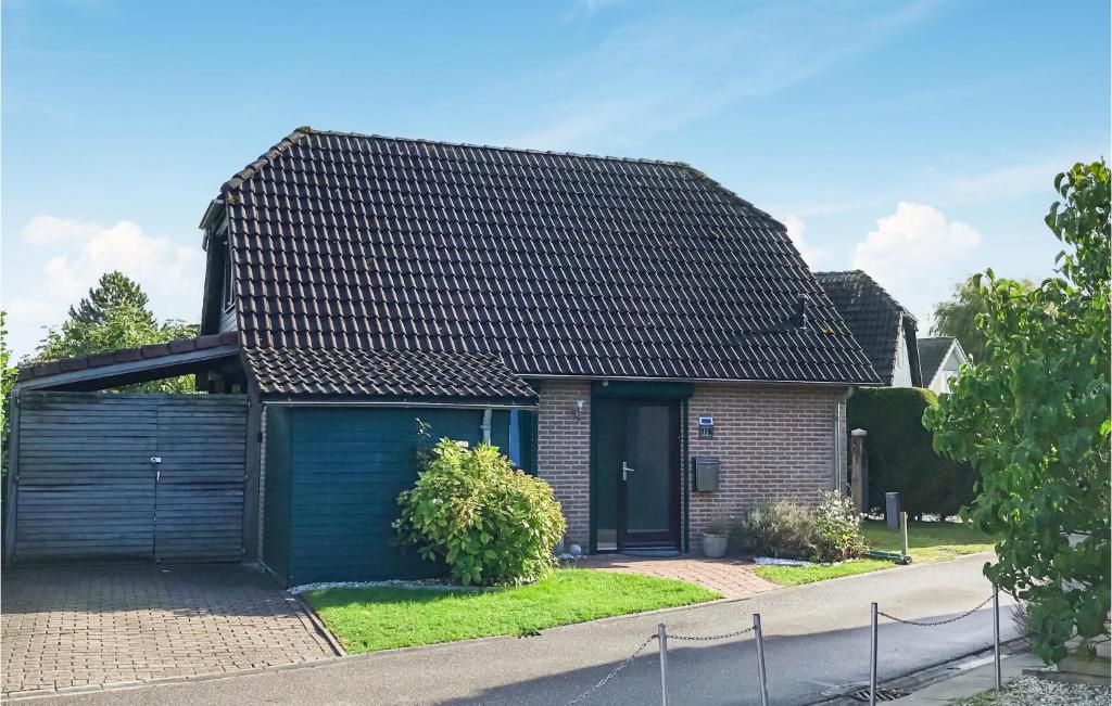 una casa con techo negro y garaje azul en Stunning Home In Wolphaartsdijk With Kitchen, en Wolphaartsdijk