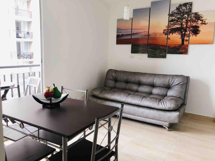 - un salon avec un canapé en cuir et une table dans l'établissement Moderno APTO con aire acondicionado y Netflix en Villavicencio, à Villavicencio