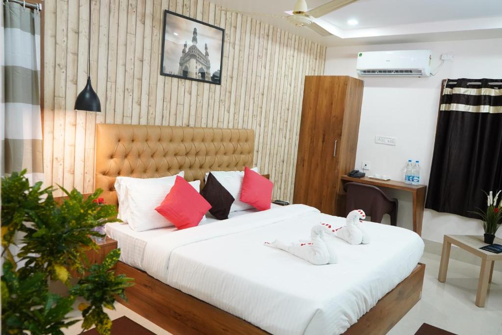 a bedroom with a large white bed with colorful pillows at Homey Meadows - Beach Area in Visakhapatnam