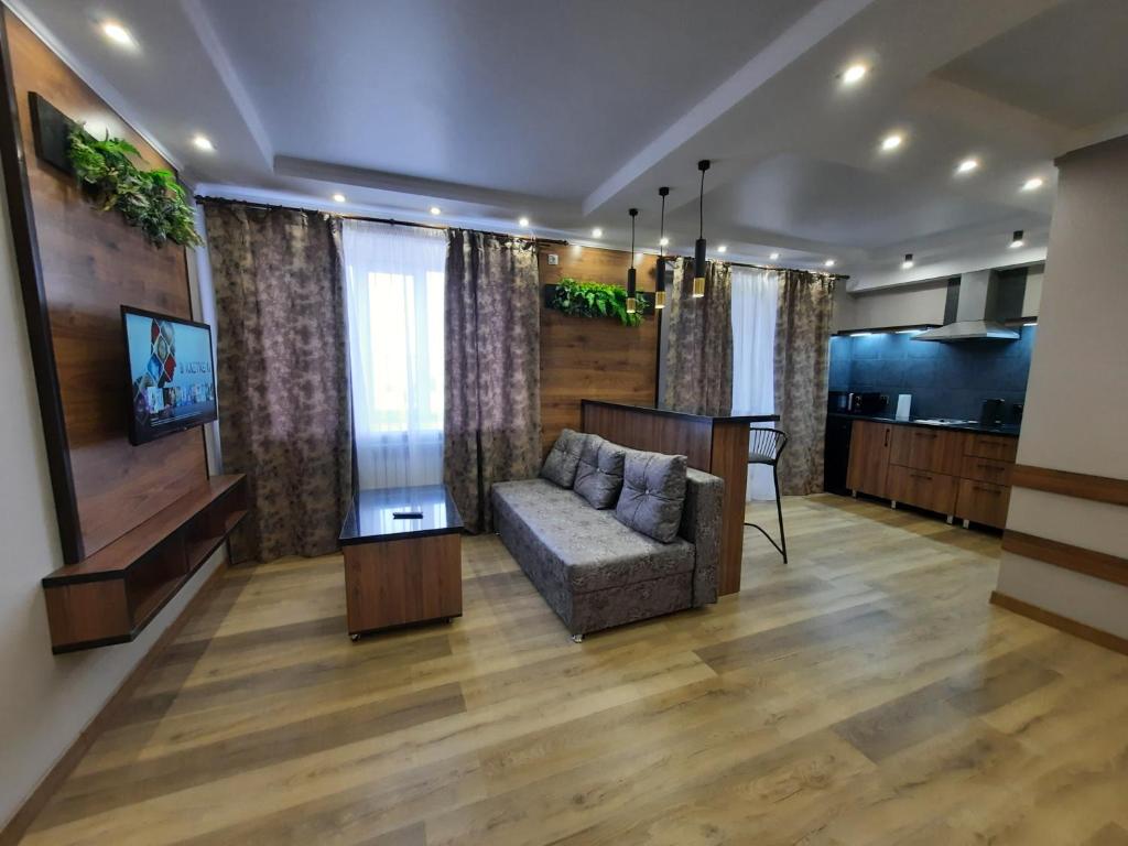 ein Wohnzimmer mit einem Sofa und einem TV in der Unterkunft Исы Байзакова 133 in Pawlodar