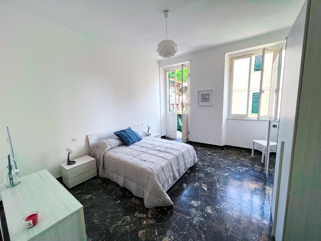 a white bedroom with a bed and a window at Chez Thérèse in Sestri Levante