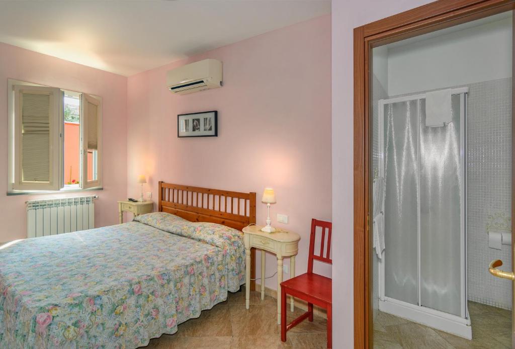 a bedroom with a bed and a table and a chair at La Papaya in Marina di Pisa