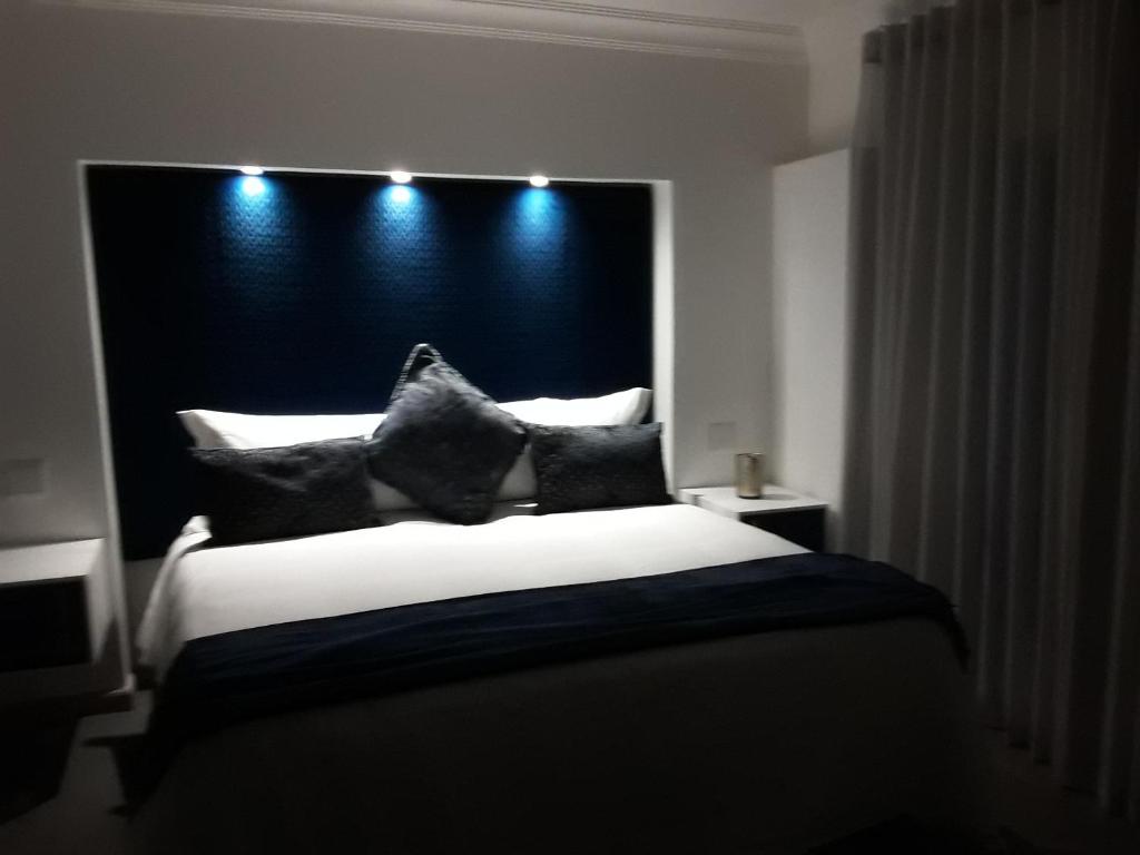 Van RiebeekhoogteにあるLe Rubis Guesthouseのベッドルーム1室(大型ベッド1台、白黒の枕付)