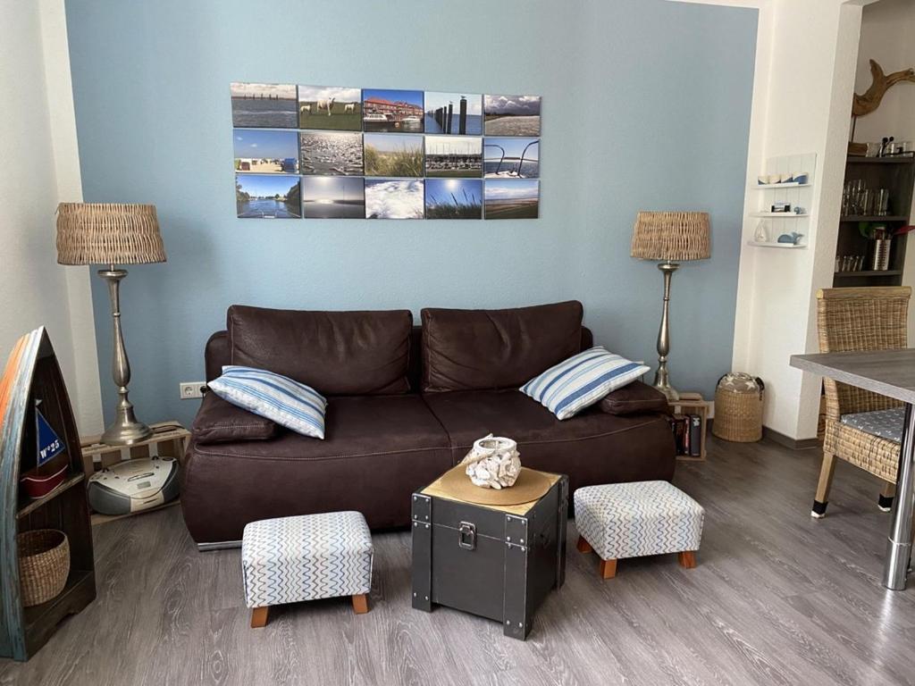 ein Wohnzimmer mit einem braunen Sofa und einem Tisch in der Unterkunft Ferienwohnungen Felix und Jan in Horumersiel