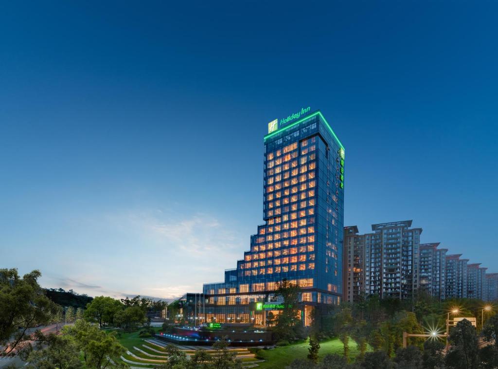 un edificio alto en una ciudad por la noche en Holiday Inn Luzhou Longjian, an IHG Hotel, en Luzhou