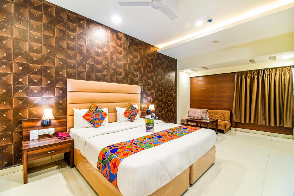 FabHotel Prime President- Near to Bhopal Airport في بوبال: غرفة نوم بسرير كبير في غرفة