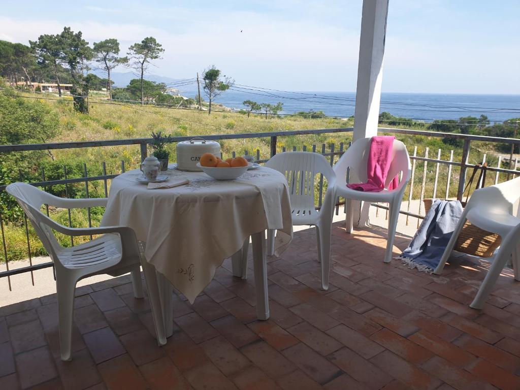 a table and chairs on a patio with a view of the ocean at Xaloc, apartament amb vistes a mar M4 in Port de la Selva