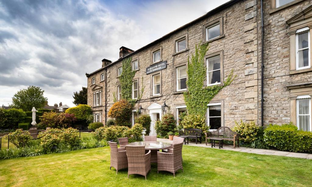 a building with a table and chairs in the yard at The Burgoyne in Reeth