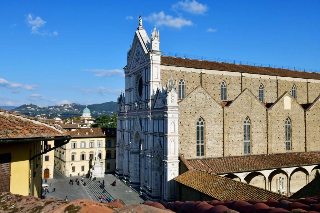 a large building with a clock tower on top of it at La Croce d'Oro Santa Croce Suite Apartments in Florence