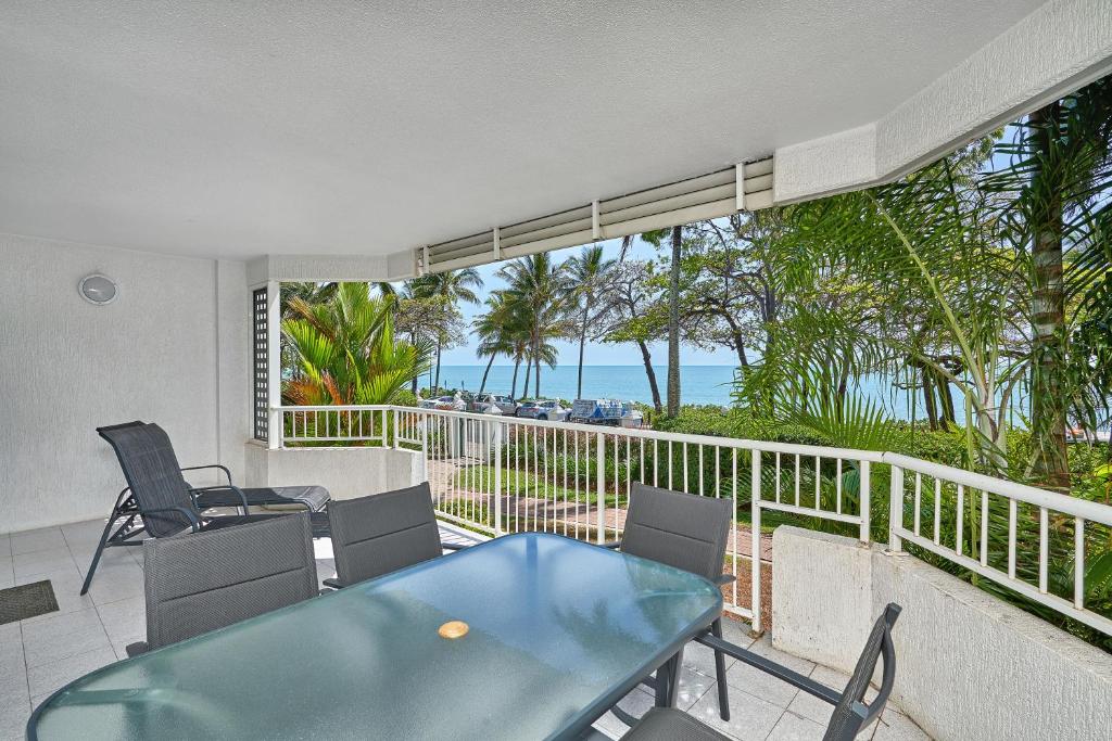 a dining room with a view of the ocean at Costa Royale Beachfront Apartment in Trinity Beach