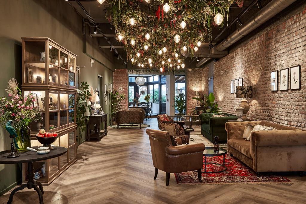 een woonkamer met een bank en stoelen en een bakstenen muur bij Urban Yard Hotel in Brussel