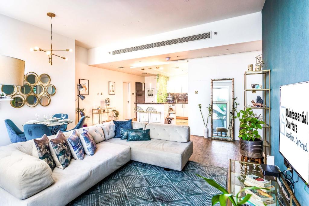 a living room with a couch and a tv at Private Urban Jungle Hideout - 2BR - Dubai Marina in Dubai