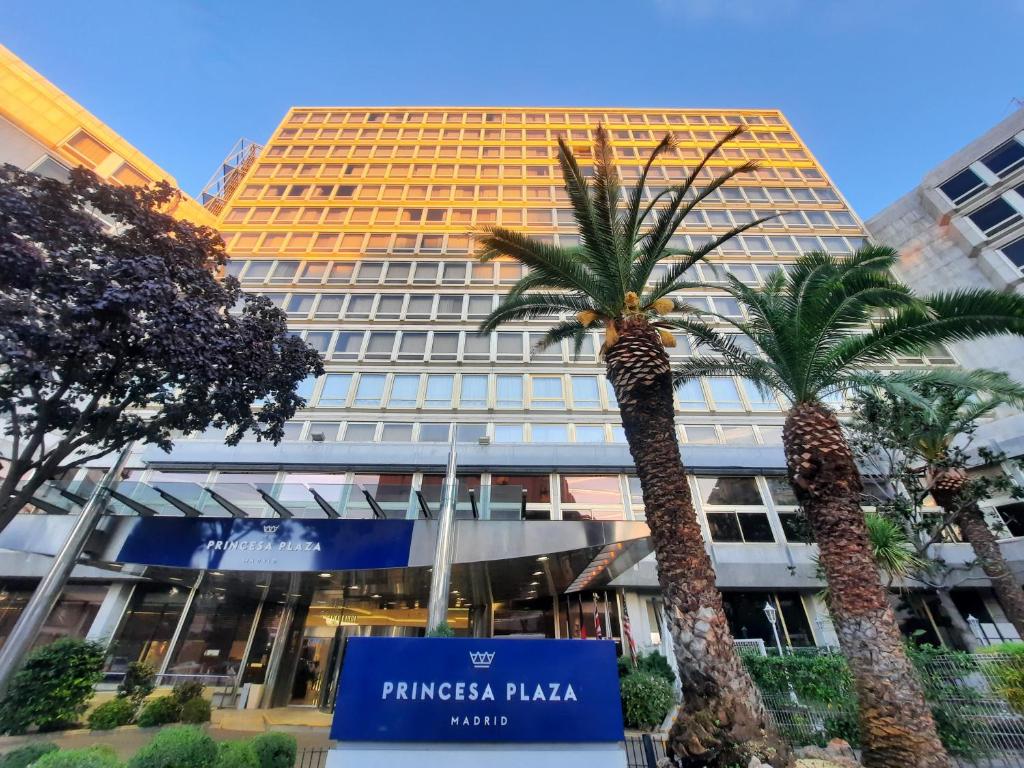 マドリードにあるHotel Princesa Plaza Madridのヤシの木が2本前に建つ建物