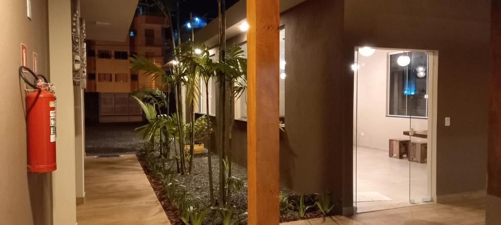 un couloir avec des plantes en pot dans un bâtiment dans l'établissement Fric Pousada, à Ubatuba