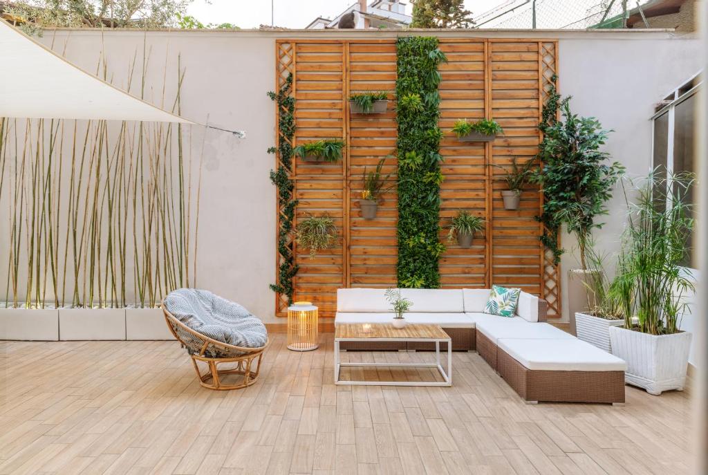 a patio with a white couch and a table and some plants at G&G Green Garden - Appartamento con Ampio Terrazzo esterno By followgreenhouserome in Rome