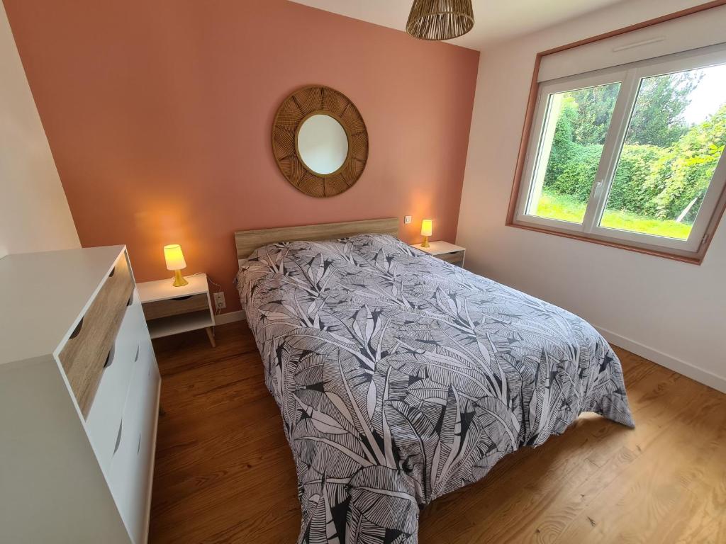 een slaapkamer met een bed en een spiegel aan de muur bij Le calme de la nature à 8 minutes des plages in Sémussac