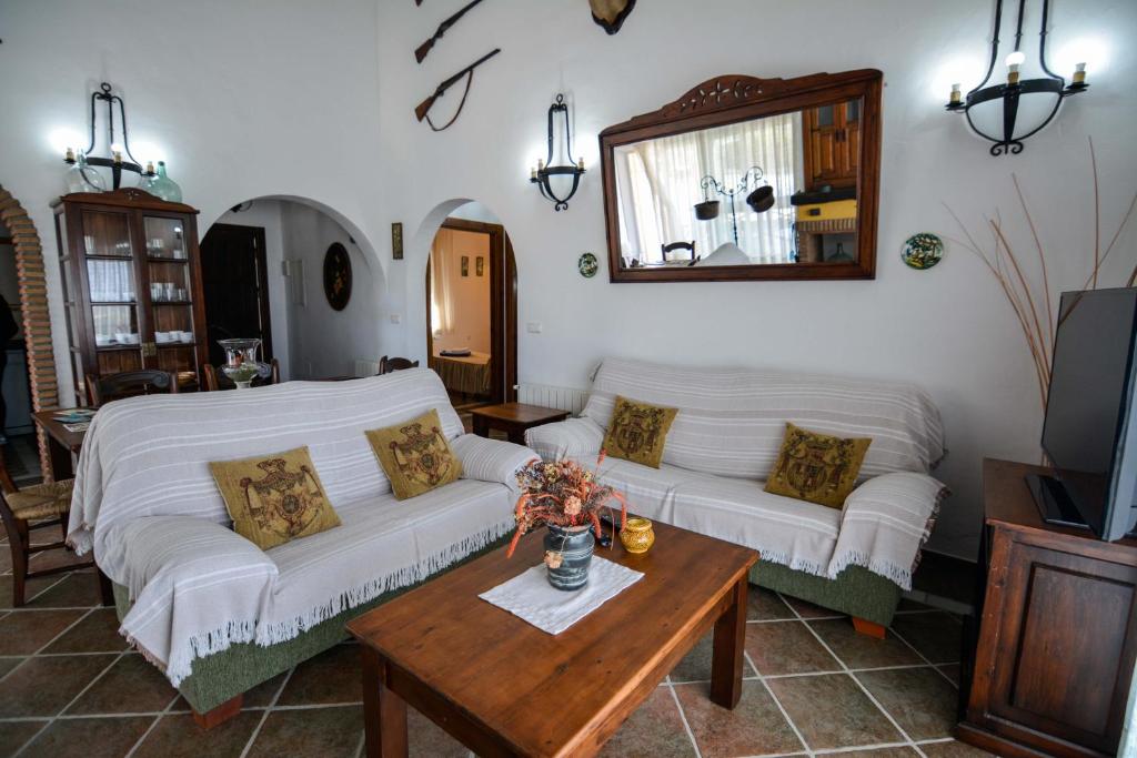 una sala de estar con 2 sofás blancos y una mesa. en Tu Villa Rural Alakran 2 Dormitorios, en Alhaurín el Grande
