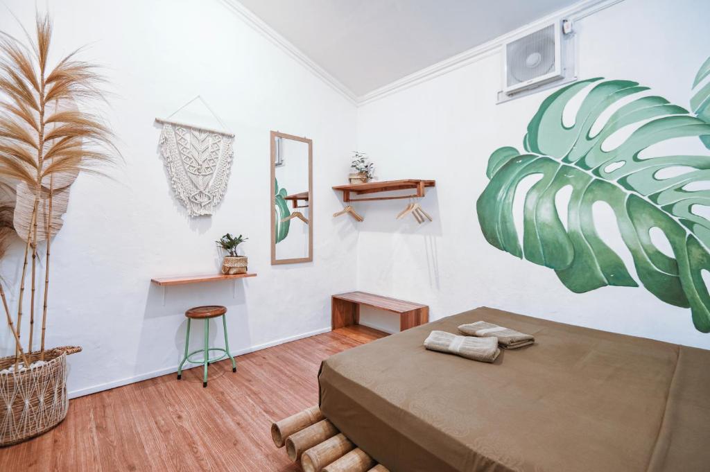 a room with a bed and a plant on the wall at Snooze in Yogyakarta
