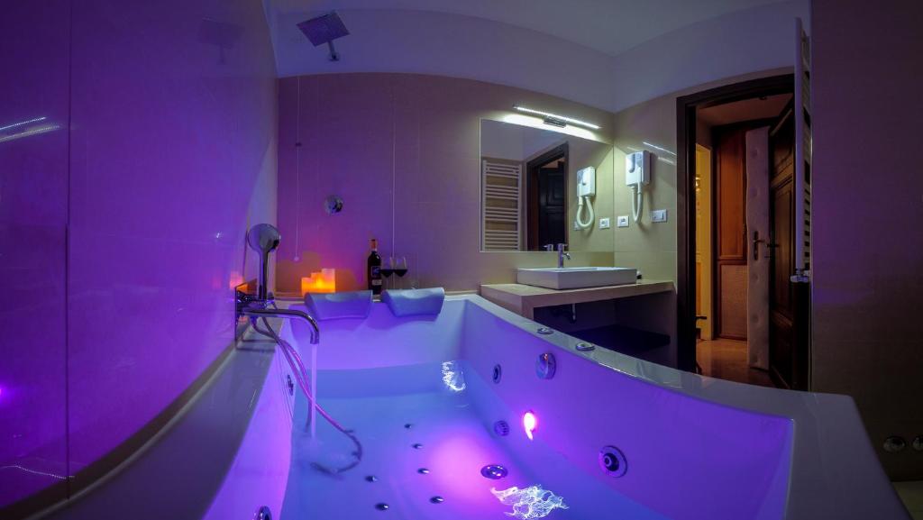 ein lila Badezimmer mit einer Badewanne und einem Waschbecken in der Unterkunft Navona Central Suites in Rom