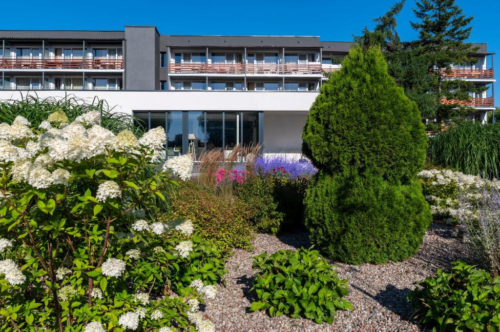 a garden in front of a building at Ośrodek Wypoczynkowo-Rehabilitacyjny "Bryza" in Dźwirzyno