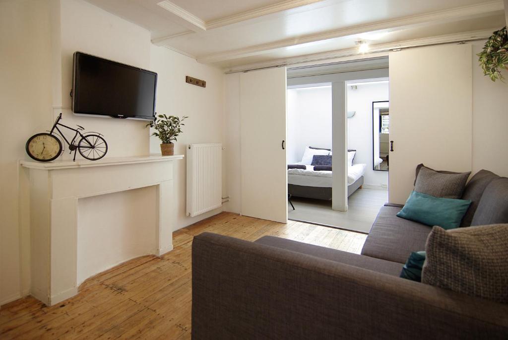 a living room with a couch and a tv at Cosy apartment right in the city center with AIRCO! in Amsterdam