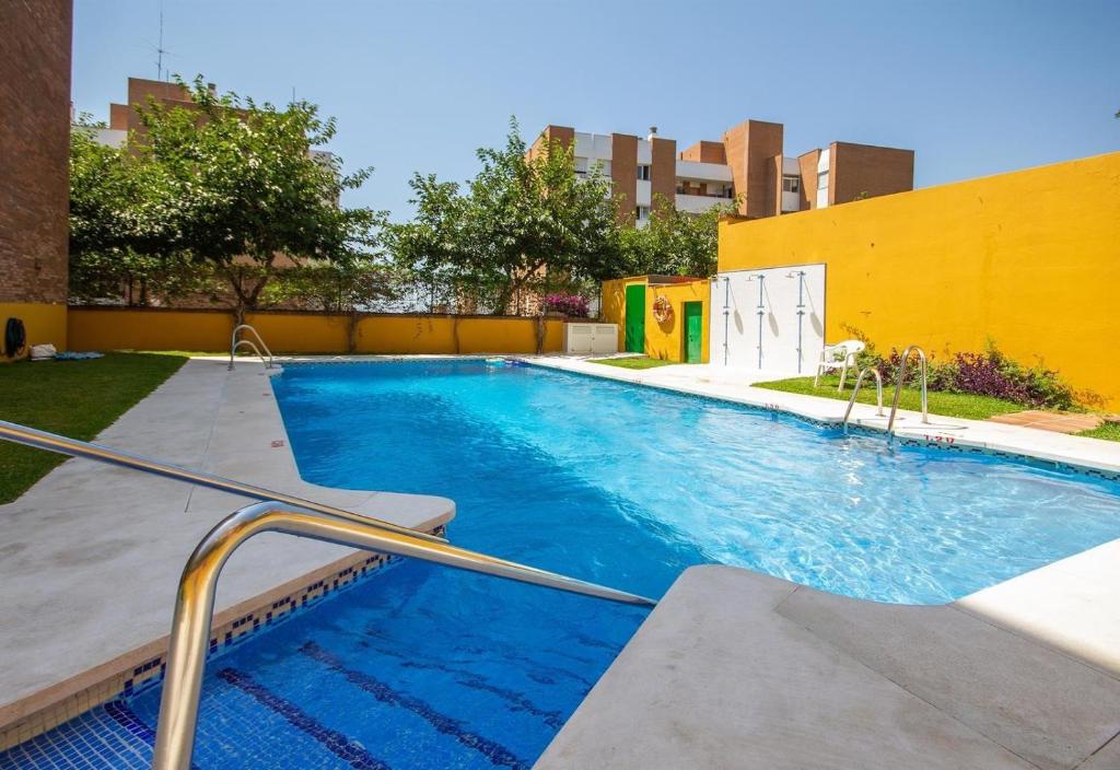a swimming pool with blue water in a building at Beautiful renovated apartment in Benalmádena