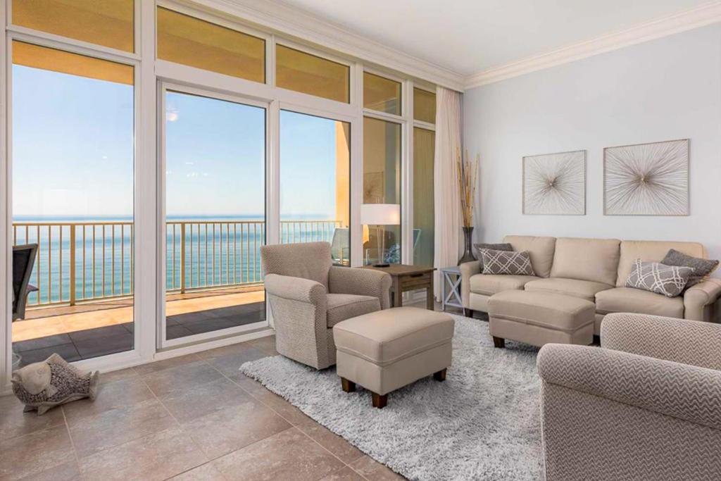 a living room with a couch and chairs and a balcony at Phoenix Gulf Shores in Gulf Shores