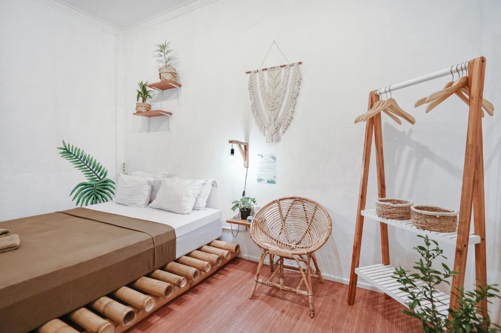 a bedroom with a bed and a chair in it at Snooze in Yogyakarta