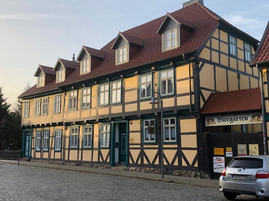 a yellow and brown building with a red roof at Pension Hansehof in Salzwedel