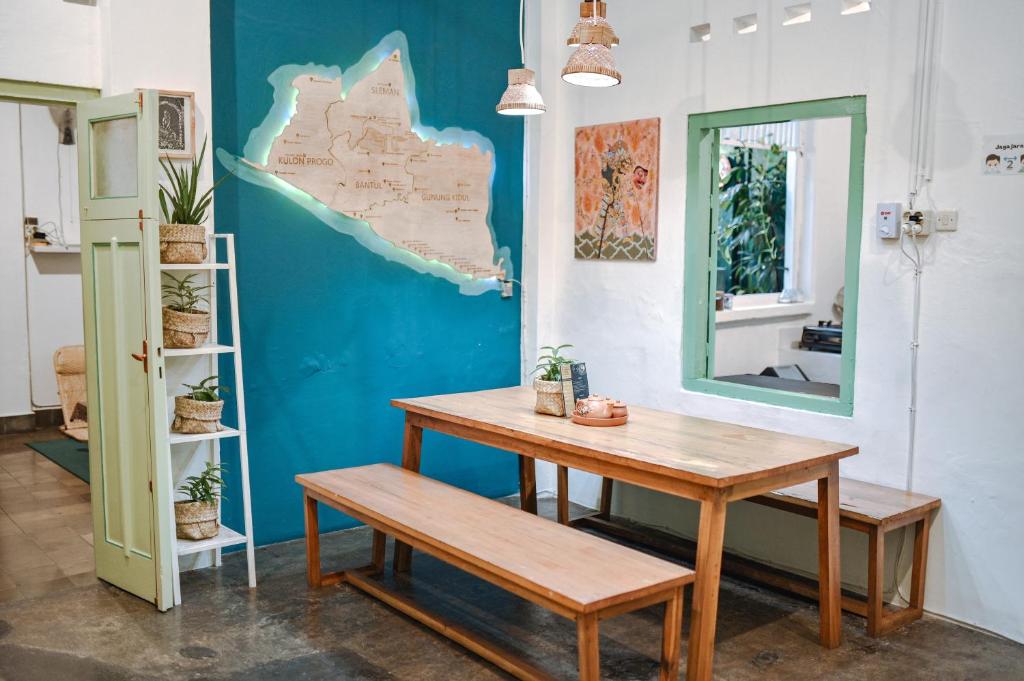 a table and bench in a room with a blue wall at Snooze in Yogyakarta