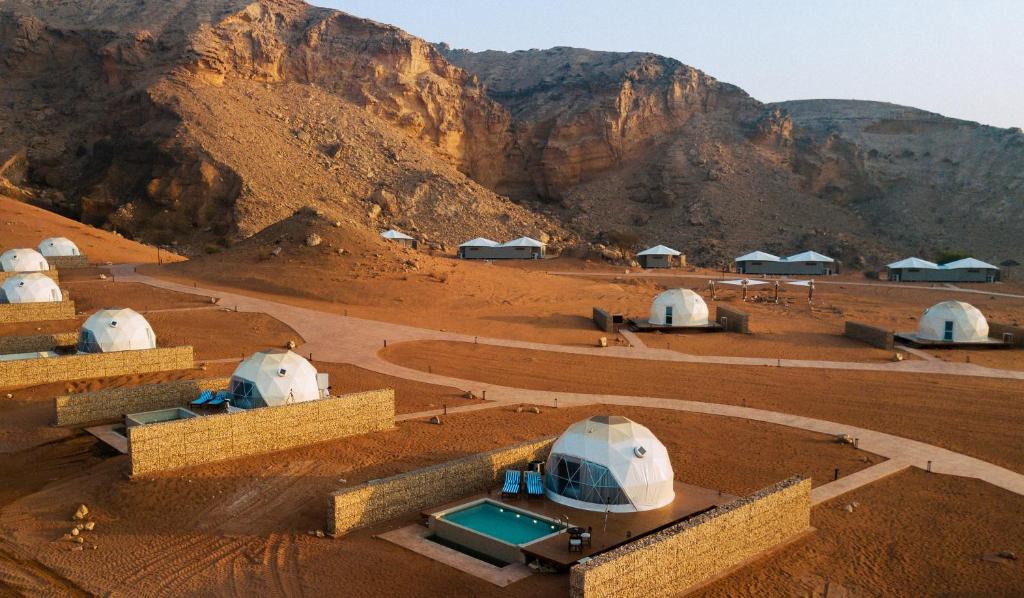 a group of domes in a desert with a mountain at Mysk Moon Retreat in Sharjah