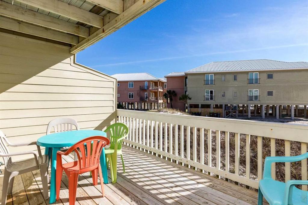 a balcony with chairs and a table on a deck at Ft Morgan Town Homes in Gulf Shores